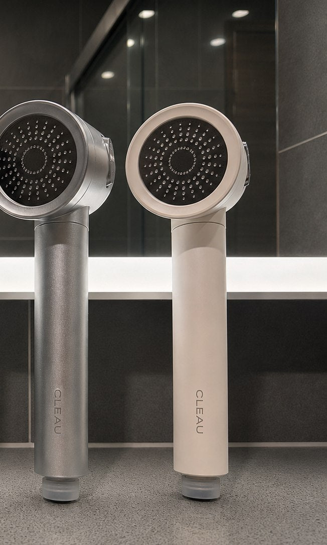 CLEAU shower heads in Space Grey and White finishes inside a modern glass-enclosed shower